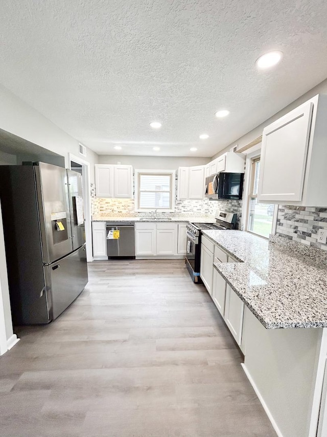 384 N Grand Ave, Bradley, IL 60915 - kitchen with stainless steel appliances, a sink, a textured ceiling, white cabinetry, and decorative backsplash