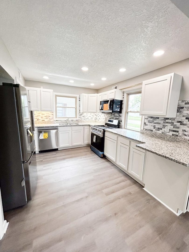 384 N Grand Ave, Bradley, IL 60915 - kitchen featuring appliances with stainless steel finishes, a textured ceiling, decorative backsplash, light wood finished floors, and recessed lighting