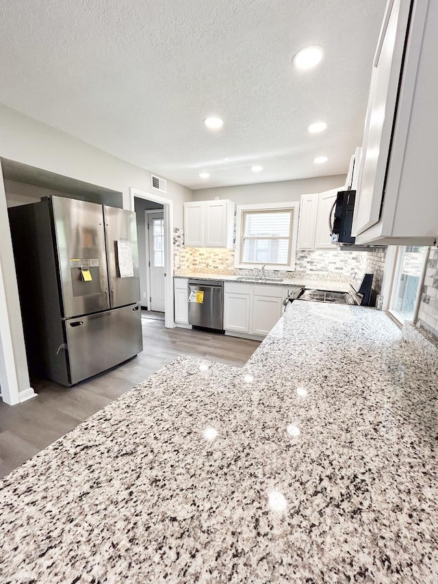 384 N Grand Ave, Bradley, IL 60915 - kitchen featuring appliances with stainless steel finishes, a sink, light stone counters, decorative backsplash, and white cabinets