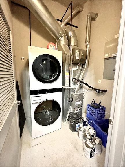 clothes washing area featuring stacked washing machine and dryer