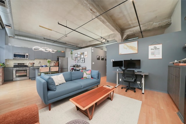 living area with light wood-style floors and a desk