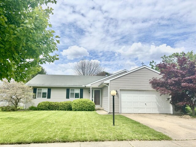 3112 Valerie Dr, Champaign, IL 61822 - ranch-style house with an attached garage, concrete driveway, a front yard, and a metal roof