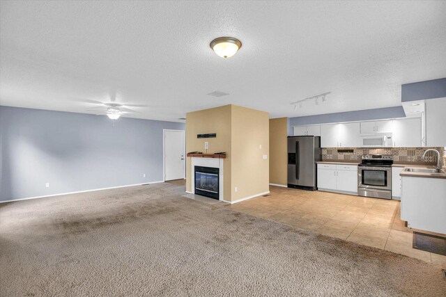 3112 Valerie Dr, Champaign, IL 61822 - kitchen with stainless steel appliances, light colored carpet, white cabinets, ceiling fan, and tasteful backsplash