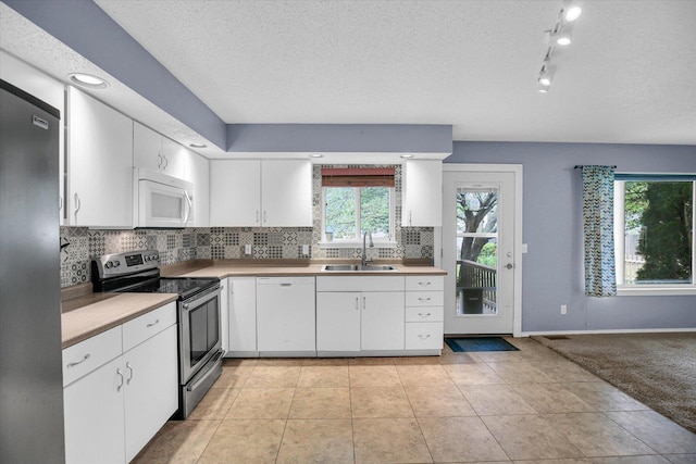 3112 Valerie Dr, Champaign, IL 61822 - kitchen with appliances with stainless steel finishes, white cabinetry, tasteful backsplash, light countertops, and a textured ceiling