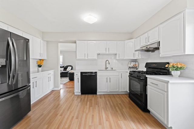 413 Caren Dr, Buffalo Grove, IL 60089 - kitchen featuring black appliances, under cabinet range hood, a sink, and backsplash