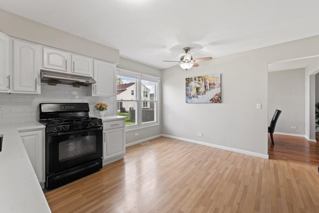 413 Caren Dr, Buffalo Grove, IL 60089 - kitchen with black gas range, under cabinet range hood, light countertops, light wood finished floors, and white cabinetry
