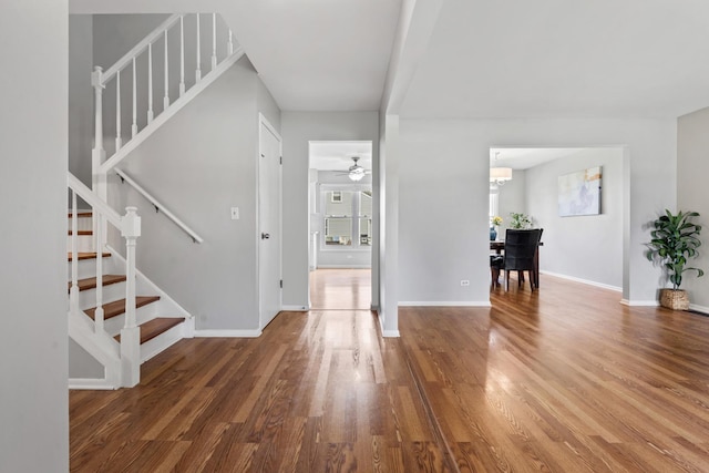413 Caren Dr, Buffalo Grove, IL 60089 - entryway featuring stairway, wood finished floors, a ceiling fan, baseboards, and a chandelier