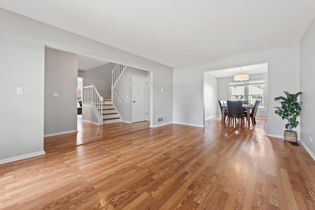 413 Caren Dr, Buffalo Grove, IL 60089 - living room with stairway, wood finished floors, a chandelier, and baseboards