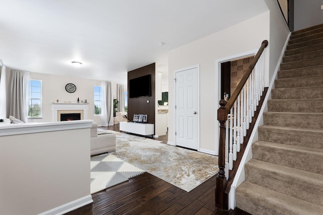 2899 Church Rd, Aurora, IL 60502 - living room featuring hardwood / wood-style flooring, stairs, baseboards, and a lit fireplace