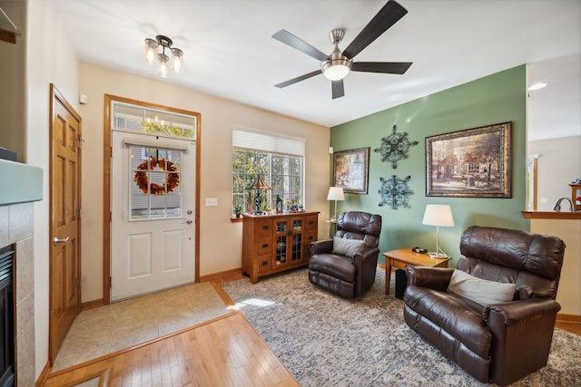 1468 W Remington Ln, Round Lake, IL 60073 - living area featuring a fireplace, light wood finished floors, a ceiling fan, and baseboards