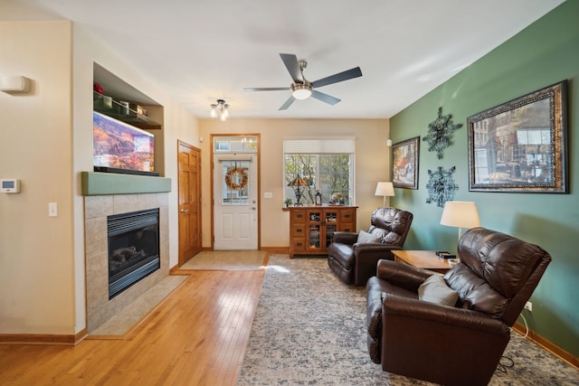 1468 W Remington Ln, Round Lake, IL 60073 - living room with hardwood / wood-style floors, a tiled fireplace, a ceiling fan, and baseboards