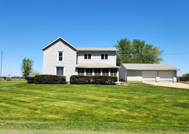 traditional-style home with a front lawn, a detached garage, and an outdoor structure