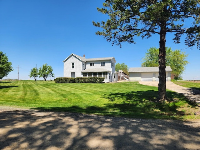traditional-style home featuring a front lawn, driveway, and a chimney