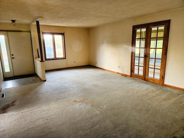 entryway with french doors, carpet floors, baseboards, and a textured ceiling
