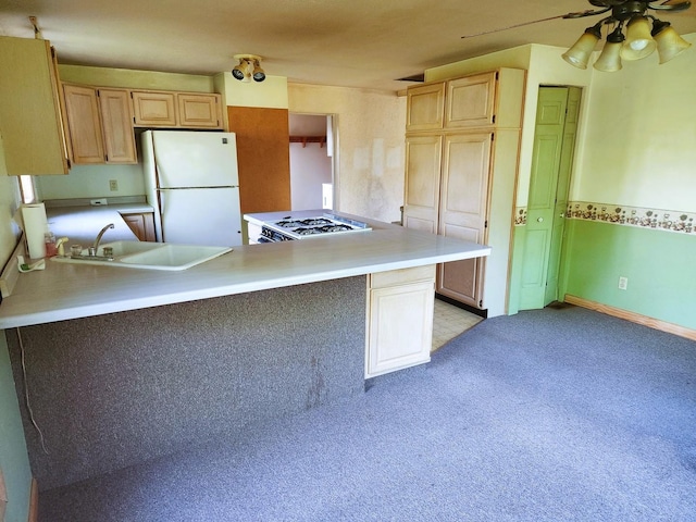 kitchen with freestanding refrigerator, a sink, light brown cabinets, and light countertops