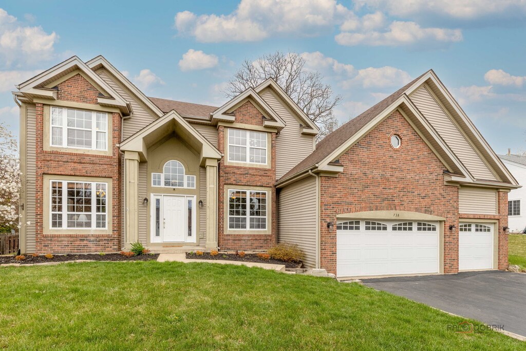 738 Saddlewood Dr, Wauconda, IL 60084 - view of front facade with brick siding, driveway, a front lawn, and a garage