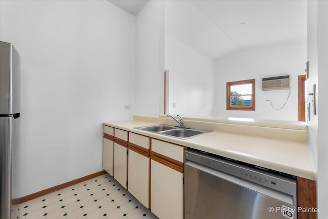 kitchen featuring appliances with stainless steel finishes, a sink, light countertops, light floors, and baseboards