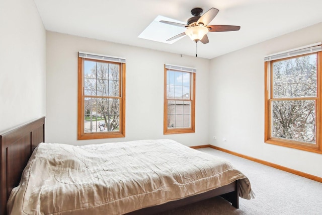 24725 Hanover Ct, Plainfield, IL 60585 - carpeted bedroom featuring multiple windows, baseboards, a skylight, and a ceiling fan