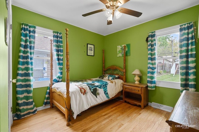 827 Lakewood Pl, Aurora, IL 60506 - bedroom featuring wood finished floors, multiple windows, baseboards, and ceiling fan