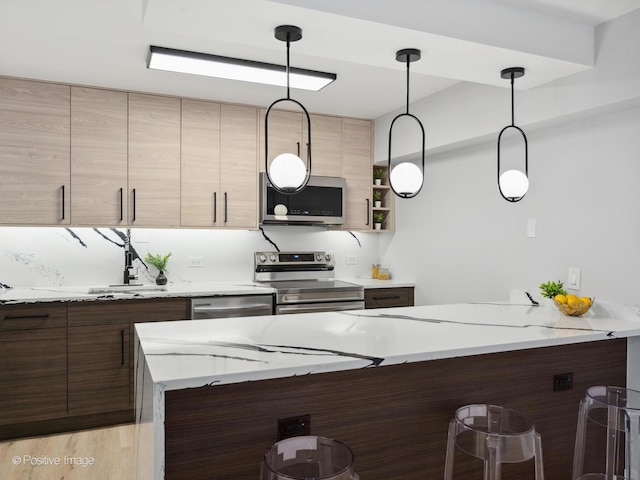 4250 N Marine Dr Unit 1929, Chicago, IL 60613 - kitchen with appliances with stainless steel finishes, a kitchen bar, modern cabinets, hanging light fixtures, and a peninsula