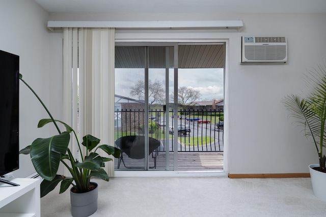doorway to outside with a wall mounted air conditioner, carpet, and baseboards