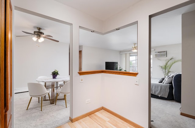 kitchen with ceiling fan, a baseboard radiator, baseboards, and open floor plan