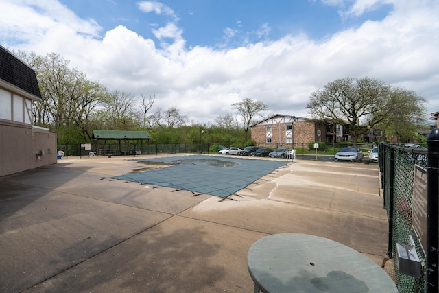 community pool with fence and a patio