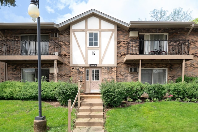 view of front of property featuring a balcony and brick siding