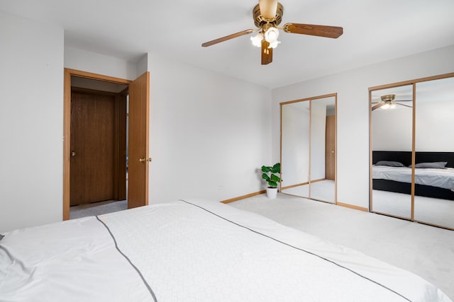 unfurnished bedroom featuring two closets, carpet floors, baseboards, and ceiling fan