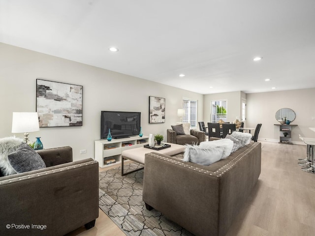living room with light wood-type flooring and recessed lighting