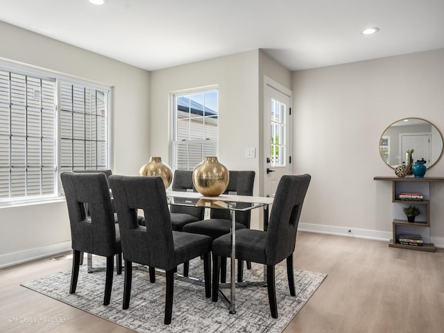 dining area featuring light wood finished floors, baseboards, and recessed lighting