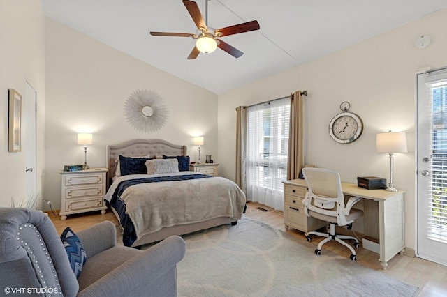 bedroom featuring vaulted ceiling, a desk, multiple windows, light wood finished floors, and baseboards