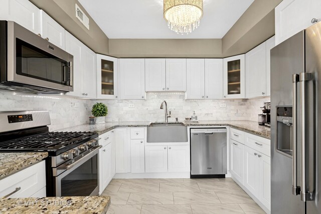 3700 N Lake Shore Dr Unit 312, Chicago, IL 60613 - kitchen with appliances with stainless steel finishes, light marble finish flooring, a chandelier, and light stone counters