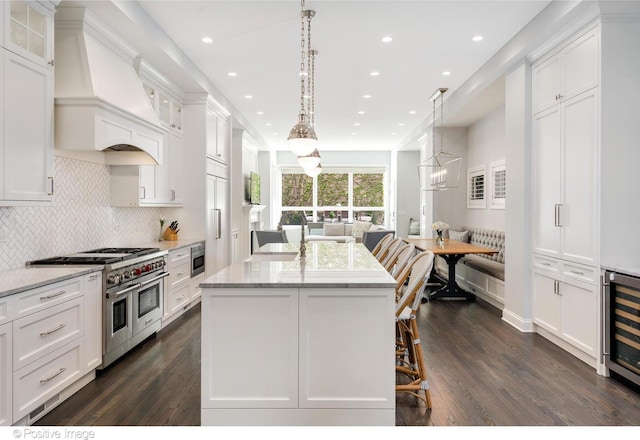 1241 W Dickens Ave, Chicago, IL 60614 - kitchen featuring double oven range, premium range hood, beverage cooler, dark wood-type flooring, and white cabinets