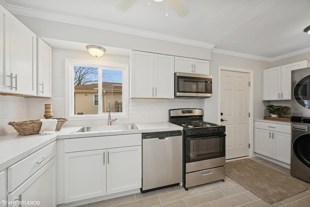 19 N Iowa Ave, Addison, IL 60101 - kitchen with stainless steel appliances, stacked washer / drying machine, a sink, white cabinets, and crown molding