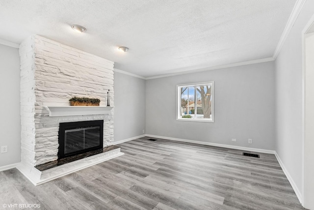 19 N Iowa Ave, Addison, IL 60101 - unfurnished living room featuring ornamental molding, a stone fireplace, a textured ceiling, wood finished floors, and baseboards