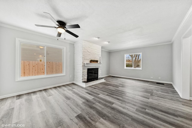 19 N Iowa Ave, Addison, IL 60101 - unfurnished living room featuring ornamental molding, a textured ceiling, a ceiling fan, a stone fireplace, and baseboards
