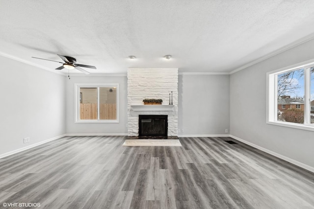 19 N Iowa Ave, Addison, IL 60101 - unfurnished living room with a textured ceiling, a stone fireplace, crown molding, baseboards, and wood finished floors