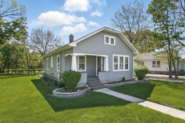 137 E Tyler St, Oswego, IL 60543 - view of front of house featuring a front lawn, a chimney, and covered porch