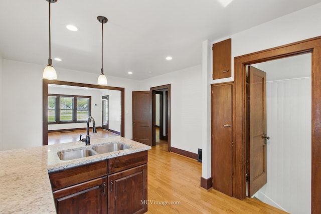 137 E Tyler St, Oswego, IL 60543 - kitchen with a sink, light wood-style flooring, hanging light fixtures, light stone countertops, and recessed lighting