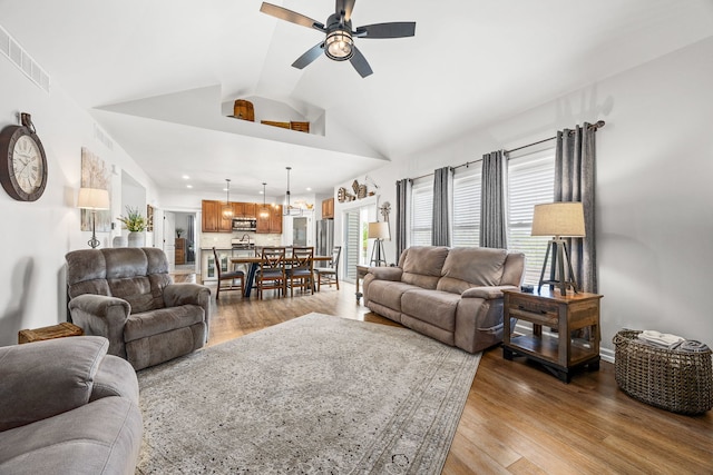 living room featuring a ceiling fan, vaulted ceiling, wood finished floors, and recessed lighting
