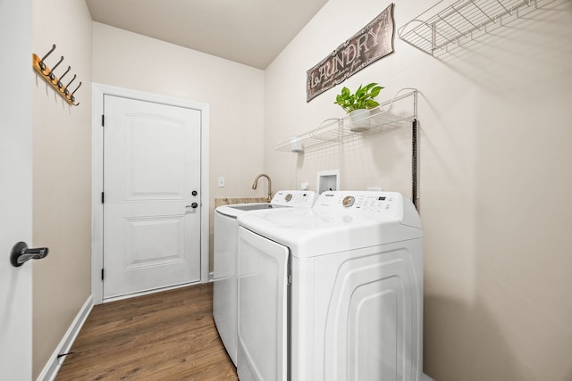 clothes washing area featuring washing machine and dryer, dark wood-style floors, and baseboards