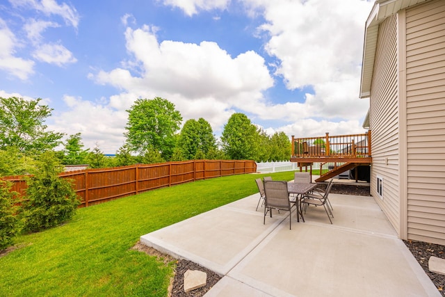 view of yard featuring a patio, outdoor dining space, and a wooden deck
