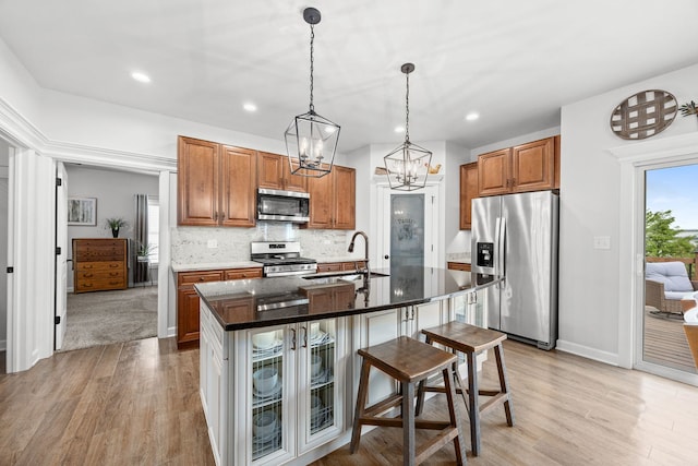 kitchen featuring appliances with stainless steel finishes, a sink, light wood-style floors, a chandelier, and recessed lighting