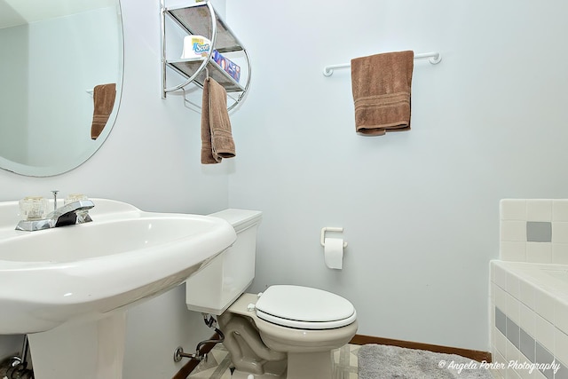 782 N Hainesville Rd, Round Lake, IL 60073 - bathroom featuring toilet, a relaxing tiled tub, and baseboards