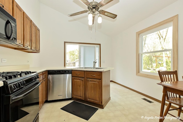 782 N Hainesville Rd, Round Lake, IL 60073 - kitchen with black appliances, a peninsula, brown cabinets, plenty of natural light, and vaulted ceiling