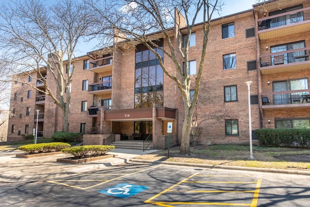 view of apartment building / complex with uncovered parking