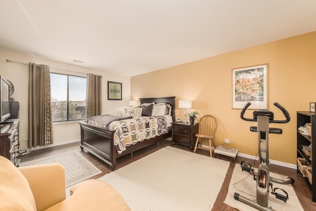 bedroom with dark wood-type flooring and baseboards