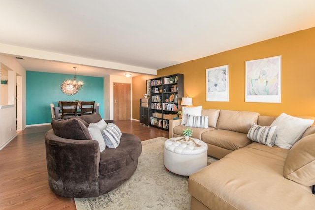 living area featuring wood finished floors, a chandelier, and baseboards