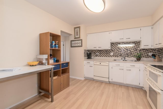 kitchen with white appliances, a sink, light wood-style floors, and backsplash